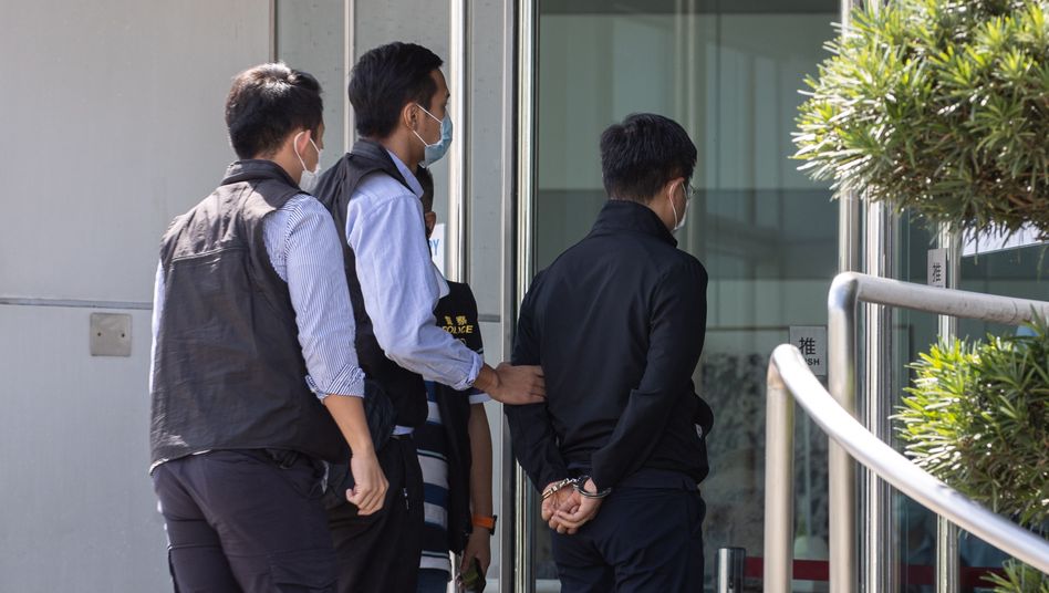 epa09278510 Apple Daily editor-in-chief Ryan Law (R) is escorted by police to the office of Next Media, publisher of Apple Daily, in Hong Kong, China, 17 June 2021. Hong Kong's national security police arrested Law and four other directors of the Apple Daily newspaper on suspicion of conspiracy to collude with foreign forces, under China-imposed legislation.  EPA/JEROME FAVRE